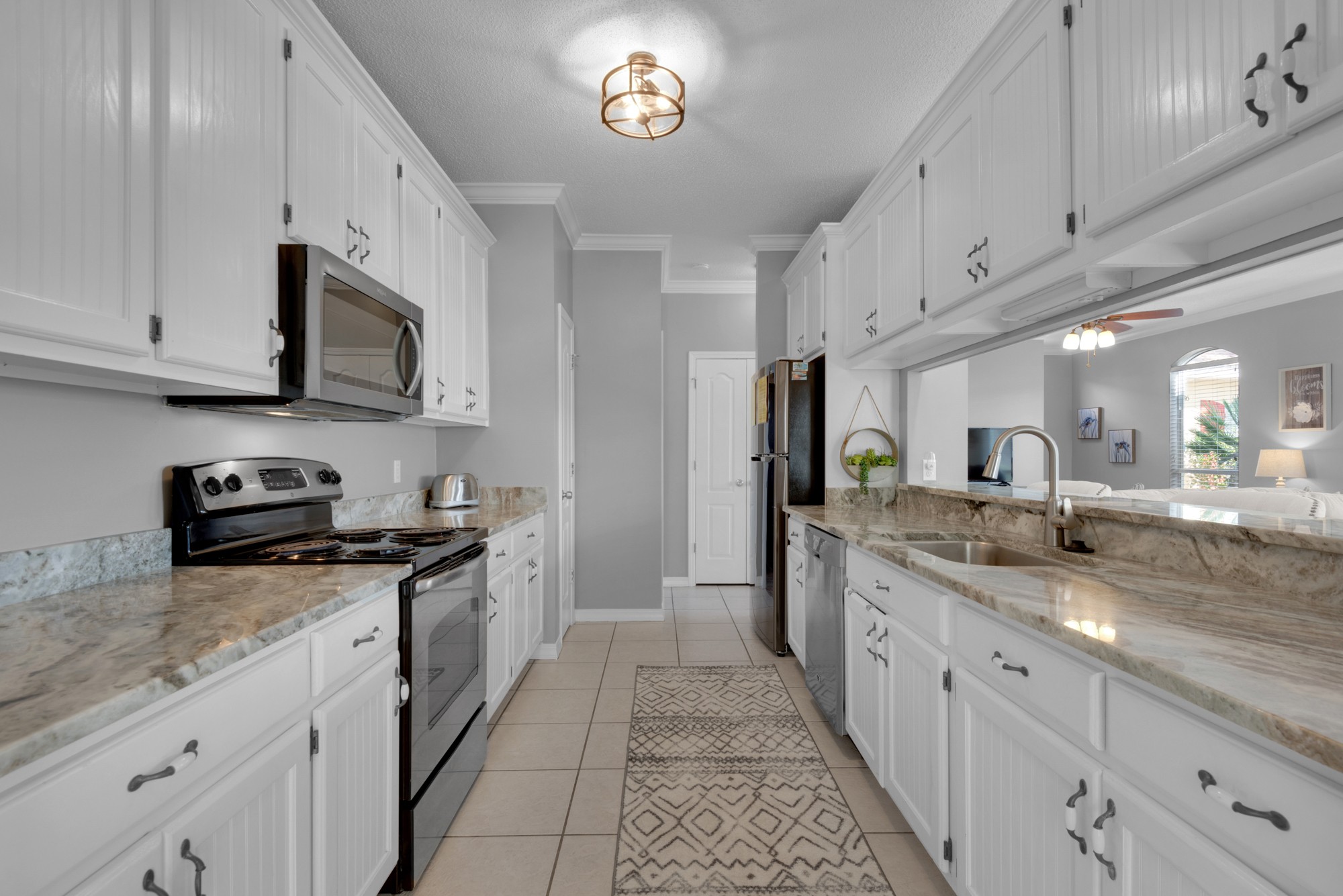 Galley style kitchen features granite countertops and stainless appliances!