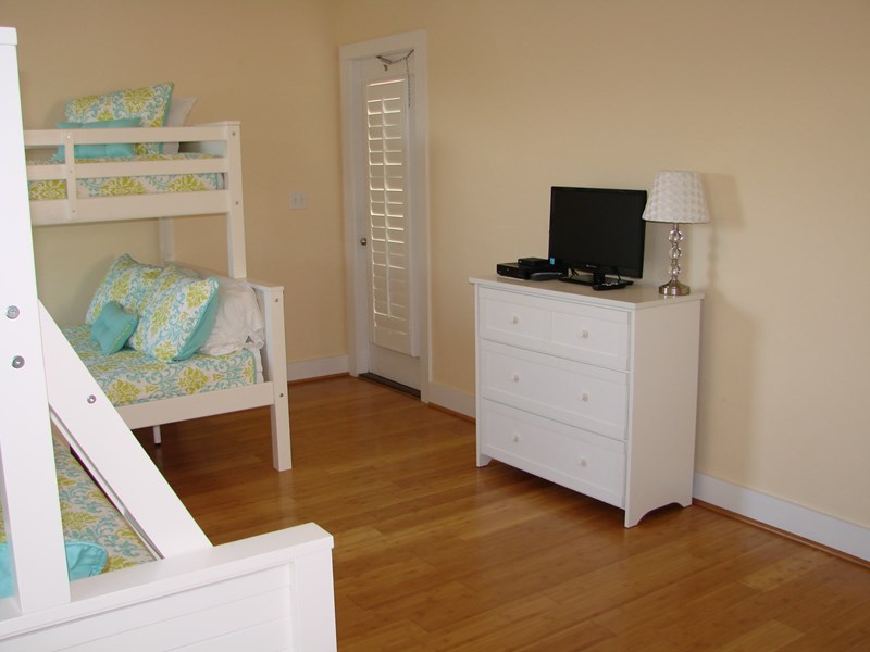 Bunk room features a flat screen tv as well as an attached bath & access to balcony.