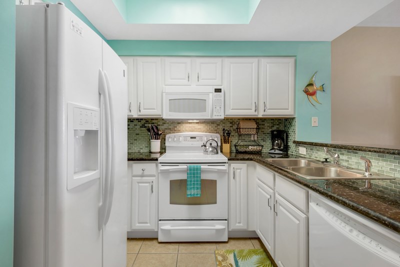 Kitchen features tiled backsplash and granite countertops
